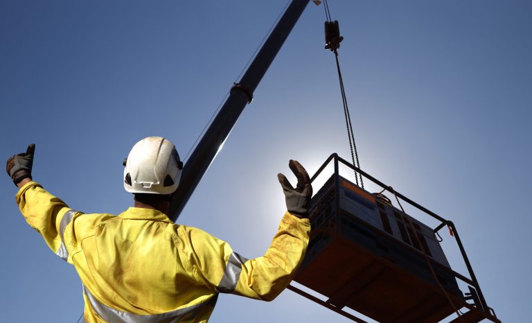 Rigger wearing a safety glove standing using a hand signal
