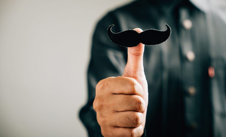 A,Man's,Thumb,Holds,A,Mustache,,Signifying,Support,For,Those